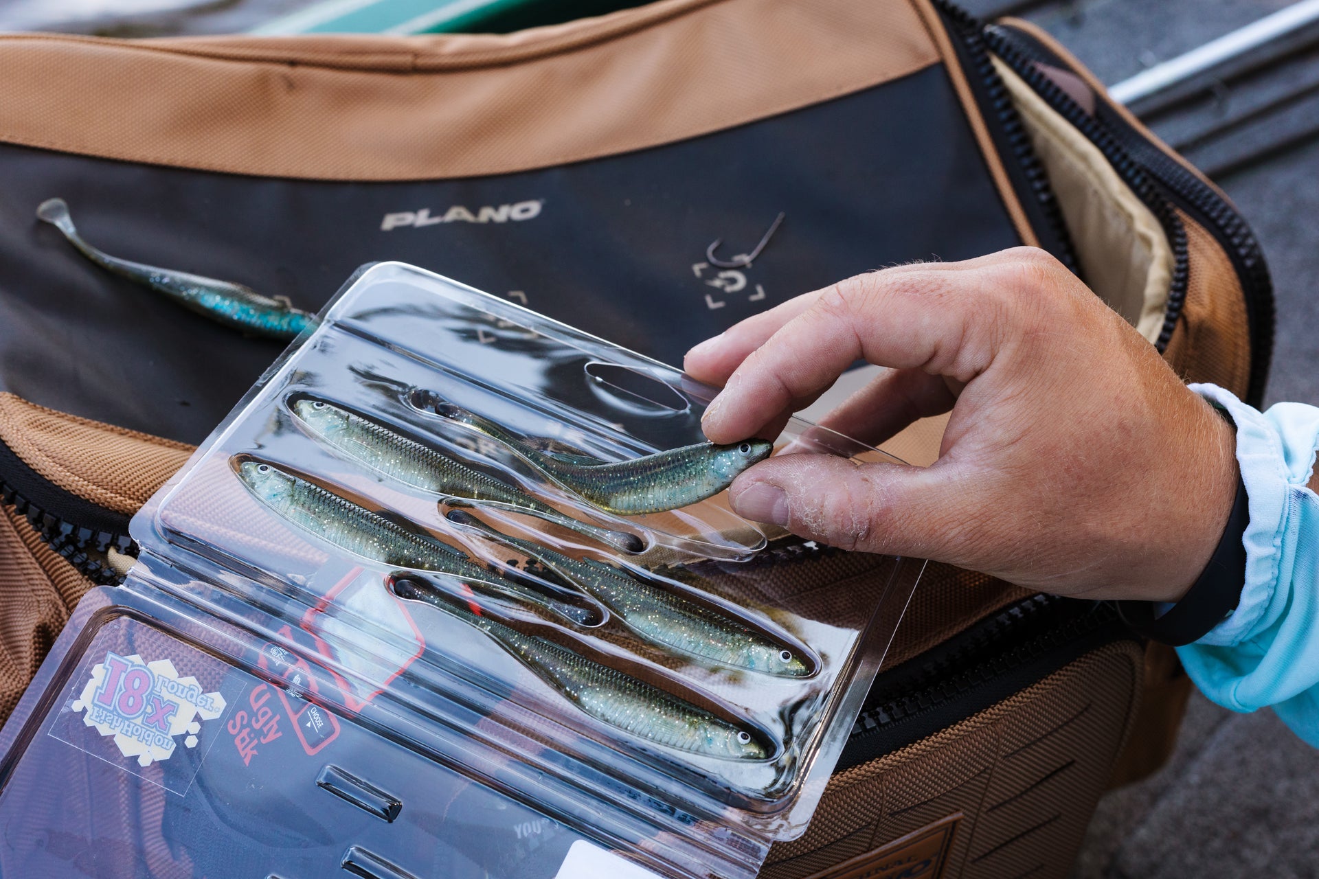 Angler taking a Berkley PowerBait Drip Minnow bait out of the packaging to use