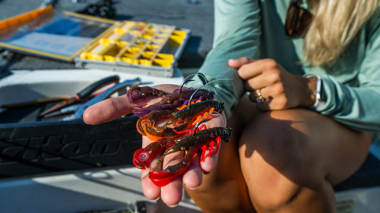 Berkley PowerBait® Clatter Craw bait resting in women's hand while sitting on a fishing boat